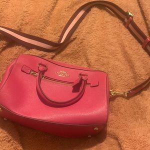 This is an bright pink coach bag, the strap is adjustable